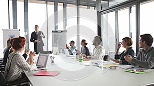 Colleagues applauding director during a meeting in conference room