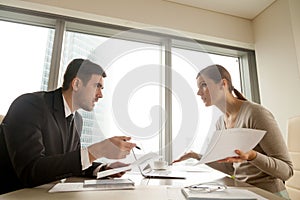 Colleagues arguing at workplace, disagree about document, error photo