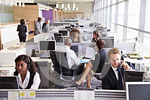 Colleagues busy working at desks in an open plan office photo