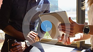 Colleagues are collaborating on tablet with coffee and smartwatch in flat design office scene