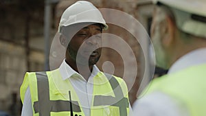 Colleagues discussing construction project at building site