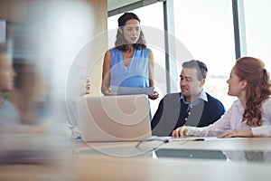 Colleagues discussing at desk during business metting