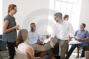 Colleagues enjoying a casual meeting in their office, close up