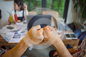 Colleagues fist bump finish up office meeting. Mission complete, teamwork power, partnership support trust