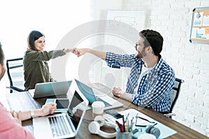 Colleagues Fist Bump To Finish Up Office Meeting