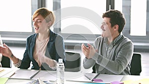 Colleagues giving high-five and applauding in conference room