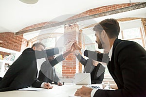 Colleagues giving high five for successful business deal