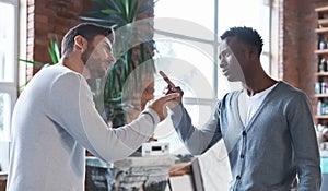 Colleagues having fight at workplace, two men fighting at job