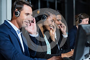 Colleagues with headsets using computer at office