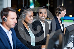 Colleagues with headsets using computer at office