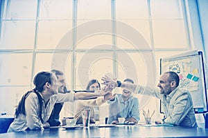 Colleagues high-five in meeting room