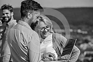 Colleagues with laptop work outdoor sunny day, nature background. Business partners meeting non formal atmosphere photo