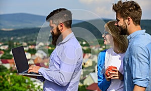Colleagues with laptop work outdoor sunny day, nature skyline background. Business partners meeting non formal