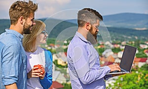 Colleagues with laptop work outdoor sunny day, nature skyline background. Business partners meeting non formal