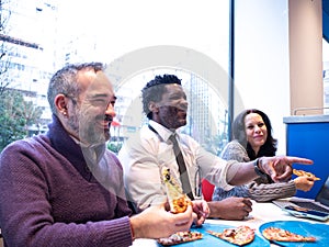 Colleagues Laughing and Pointing While Sharing Pizza photo