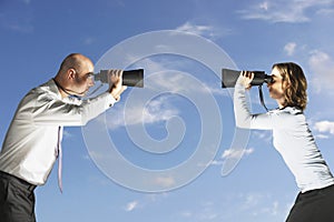 Colleagues Looking At Each Other Through Binoculars Outdoors