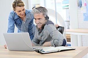 Colleagues at office working on laptop