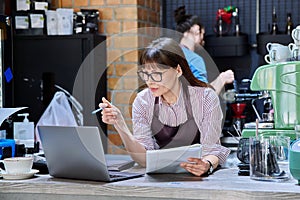 Colleagues, partners, man and woman behind counter in coffee shop