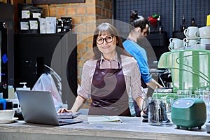 Colleagues, partners, man and woman behind counter in coffee shop