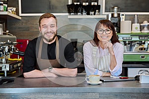 Colleagues, partners, smiling man and woman looking at camera, in coffee shop