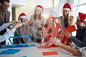 Colleagues playing at work for christmas, competing in building card towers