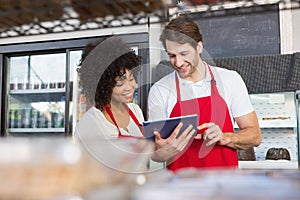 Colleagues in red apron using tablet