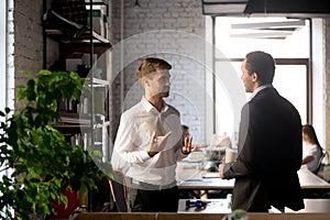 Colleagues standing having casual conversation in office photo