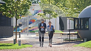 Colleagues strolling street together on lunch break. Smiling couple talking