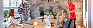 Colleagues talking in office while two of them having fun playing ping pong over coworking table