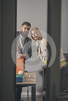 Colleagues with troubled faces look out modern office. Colleagues at meeting in office with glass walls