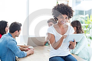 Colleagues using laptop and tablet in office