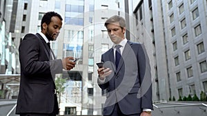 Colleagues using smartphones for online banking app convenient money transaction