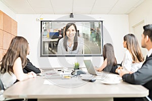 Colleagues Watching Presentation In Meeting Room