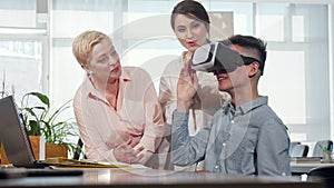 Colleagues watching young businessman using 3d vr glasses