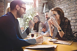 Colleagues from work socializing in restaurant and eating togeth