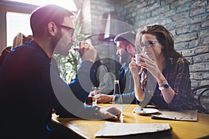 Colleagues from work socializing in restaurant and eating togeth