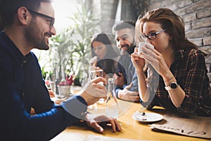 Colleagues from work socializing in restaurant and eating togeth