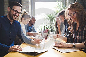 Colleagues from work socializing in restaurant and eating togeth