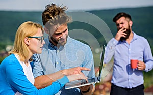 Colleagues working laptop, boss smoking while coffee break on background. Workaholics concept. Colleagues with laptop