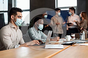 Colleagues working on a project, using laptop computers