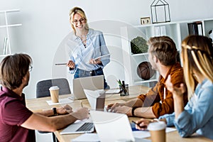 colleagues working on startup project in office and listening to manager