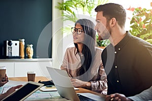 Colleagues working together at a boardroom table in an office