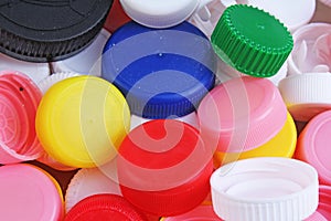 Collect plastic bottle caps. Close-up shot of stack of recyclable plastic bottle caps on white background. Bottle cap