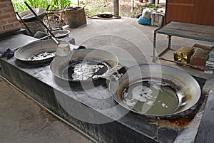 Collected coconut tree sap heated in large woks to evaporate the moisture content of the sap