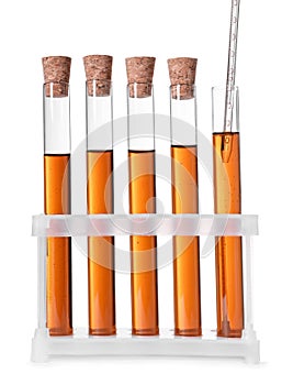 Collecting brown liquid with pipette from test tube on white background