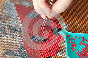 Collecting diamond embroidery, diamond mosaic. Colored crystals. Needlework. Creation. CloseUp