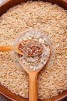 Collecting dry cereals. Buckwheat, rice, oatmeal in a large brown plate.