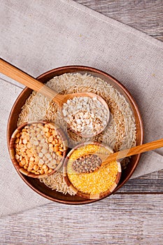 Collecting dry cereals. Buckwheat, rice, peas, oatmeal, wheat in a large brown plate.