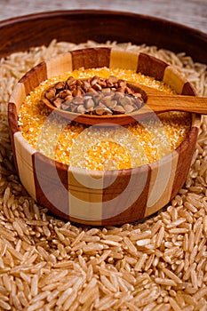 Collecting dry cereals. Buckwheat, rice, wheat in a large brown plate.