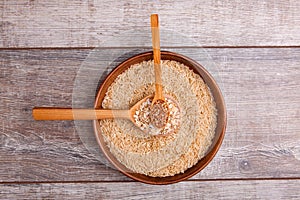 Collecting dry cereals. On a wooden background, buckwheat, rice, oatmeal in a large brown plate.